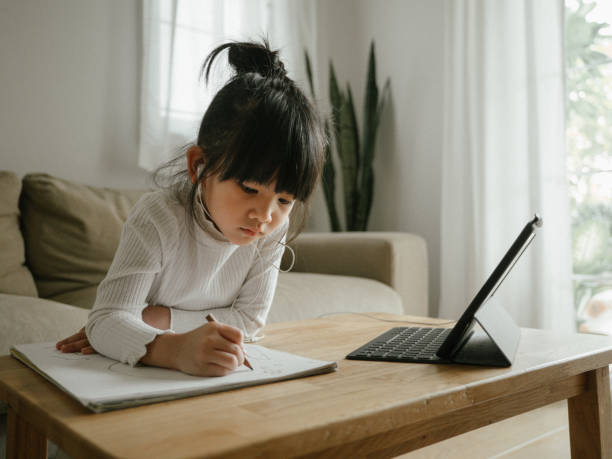 istock Little girl doing her homework with digital tablet. 1216973085
