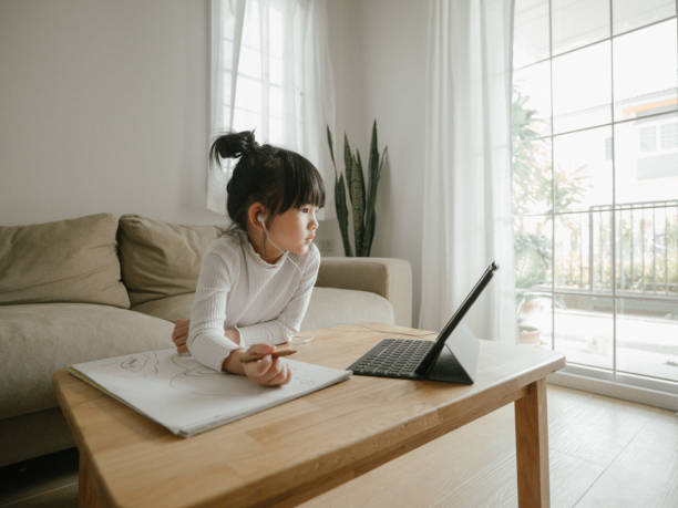 istock Asian daughter attending to online class from home. 1216973089