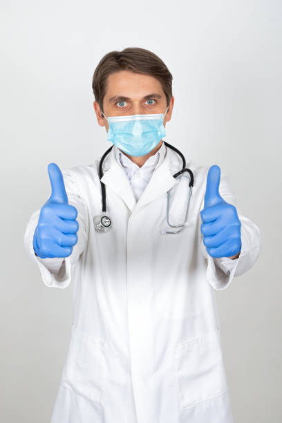 istock Physician with mask and gloves showing thumbs up 1216974391