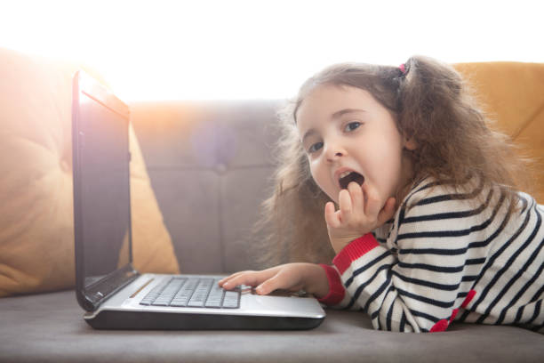 istock Cute little girl using laptop 1216977619