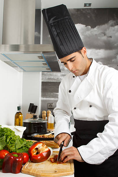 istock Chef Cutting Red Pepper on a Cutting Board in a Kitchen 121697780