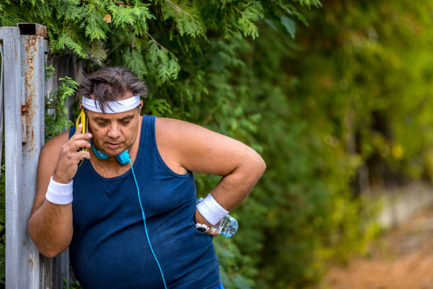 istock Overweight man talking on a phone after exercise 1216978008