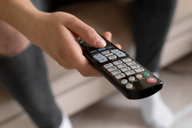 istock Young male student watching tv using the remote 1216978160