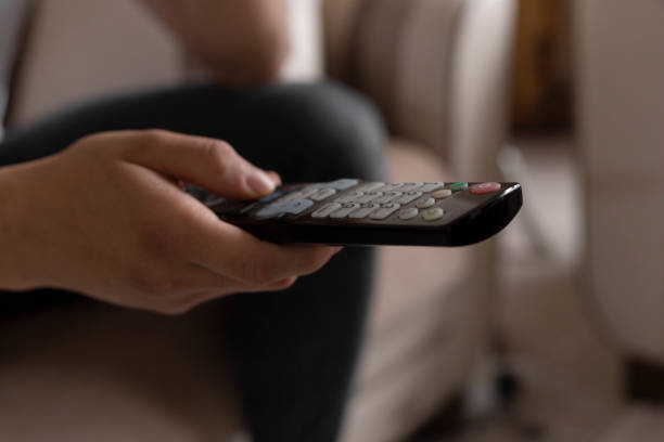 istock Young male student watching tv using the remote 1216978261