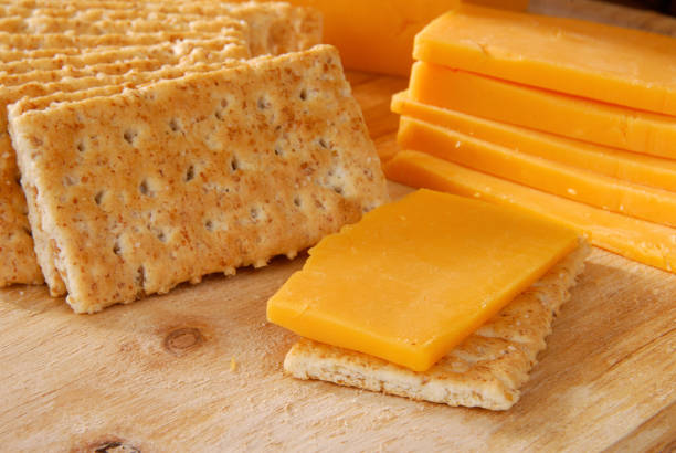 istock Slices of cheese and crackers on a wooden board 121697900