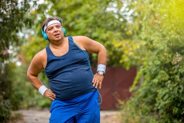 istock Overweight man warming up before jogging on the street 1216979155