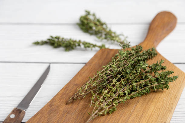 istock Close up thyme on board at white background with knife 1216982445