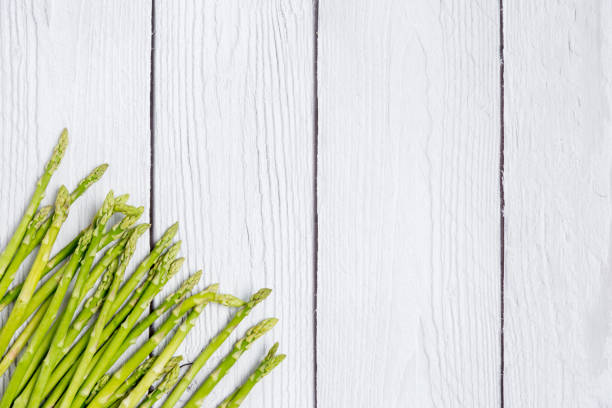 istock Space with raw asparagus on white wood background 1216982576