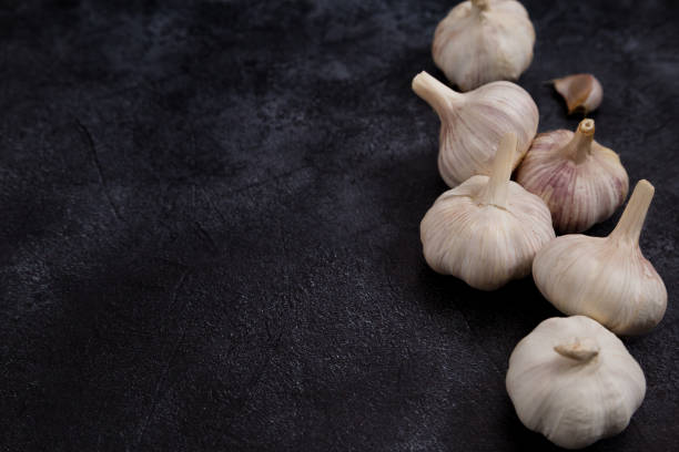 istock Heads of garlic on black background 1216982632