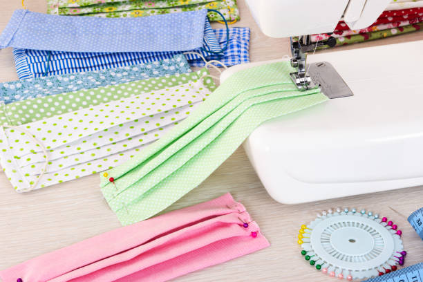 istock Sewing reusable fabric masks at home for coronavirus protection. 1216983928