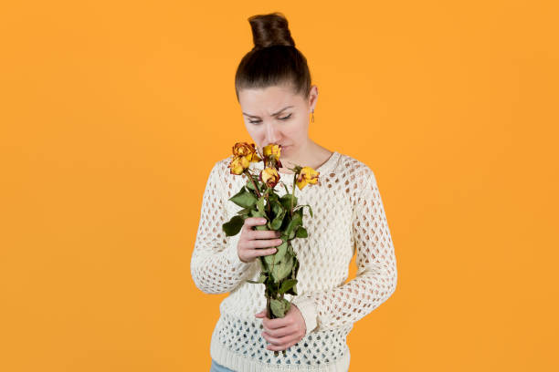 istock girl sadly looks at withered flowers 1216984390