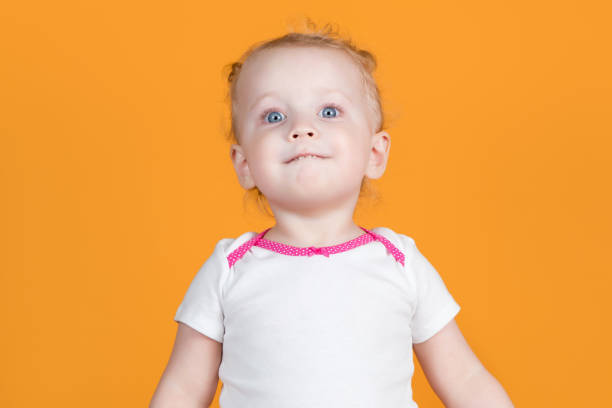 istock A little girl bites her lower lip and looks back with her head thrown back 1216984441
