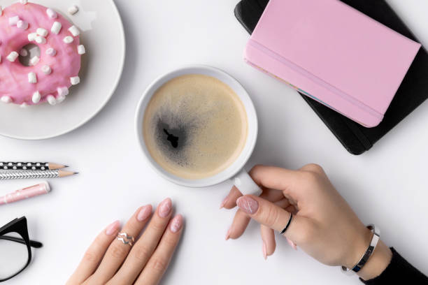 istock Manicured woman's hand holding white cup of coffee. 1216985961
