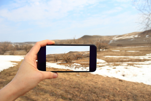tourist photographing hills with smartphone