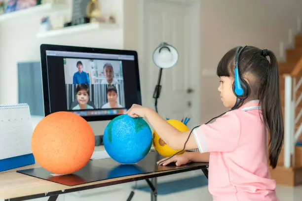 Asian girl student live learning video conference with teacher and other classmates giving presentation, showing solar model project, Homeschooling and distance learning ,online ,education and internet.