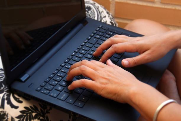 istock Hands typing in a black laptop. 1216988838