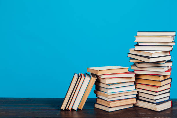 istock many stacks of educational books for learning preparation for college exams on a blue background 1216989559