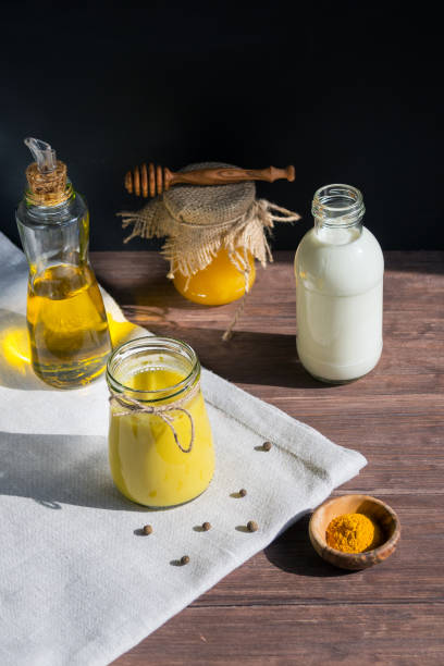 istock Turmeric-based golden milk healing drink and ingredients on black background. 1216989579