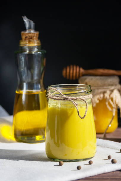 istock Turmeric-based golden milk healing drink and ingredients on black background. 1216989582