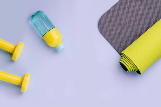 istock Dumbbells, bottle of water and a rolled mat spread out. Copy space. Top view. 1216989993