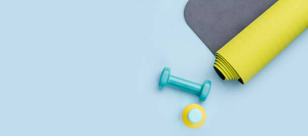 istock Things for exercise: dumbbells, bottle of water and a rolled mat. Top view. 1216989999