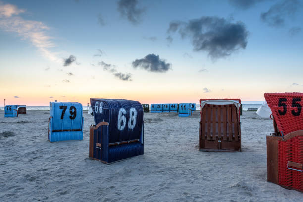 Typical roofed wicker beach chairs at the beach of Neuharlingersiel, an East Frisian village on the German North Sea Coast in Lower Saxony, Germany