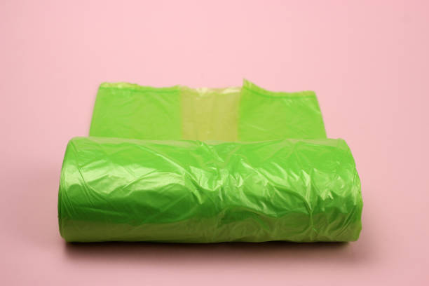 istock roll of plastic green garbage bags on pink background 1216991682