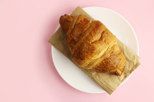 istock croissant in a white plate on a pink, colored background 1216991880