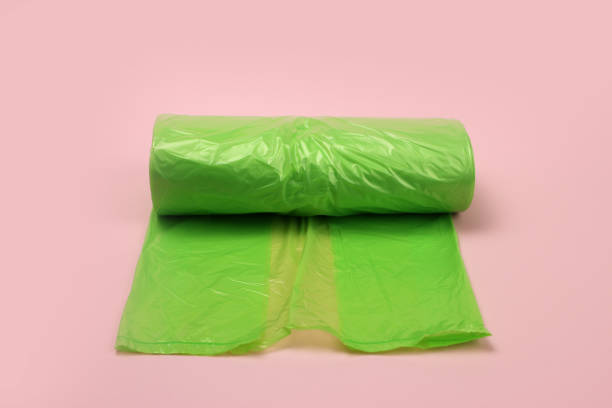istock roll of plastic green garbage bags on pink background 1216991904