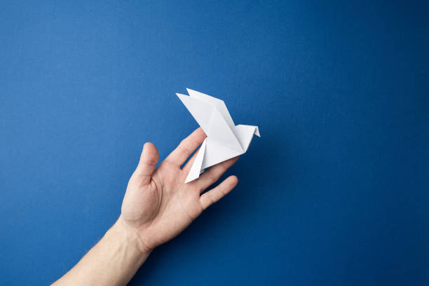 istock Paper pigeon on a blue isolated background. 1216991915