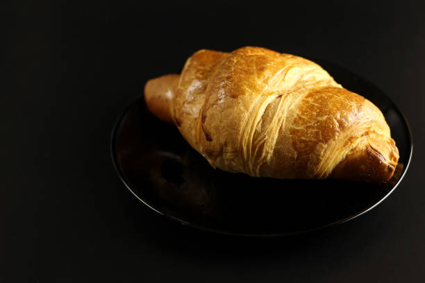 istock croissant in a black plate on a black background 1216991995