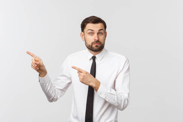 istock Young handsome businessman pointing to something using a finger. Isolated on white 1216993068