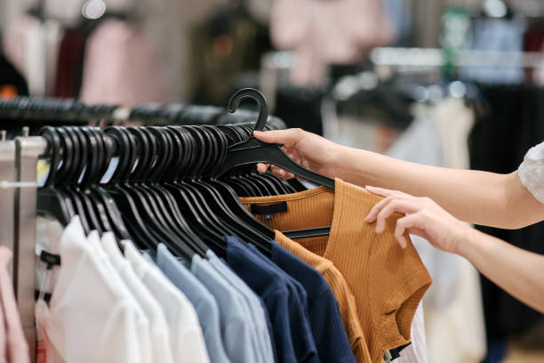 Close-up of asian chinese female hand taking a clothes out at clothing store stock photo