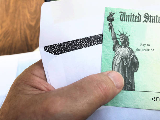 istock Senior's hand holding a Federal treasury check 1216995021