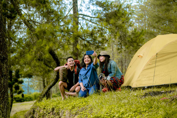 amigos felizes e desfrutar de acampar na floresta tropical - travel ipad isolated backpack - fotografias e filmes do acervo