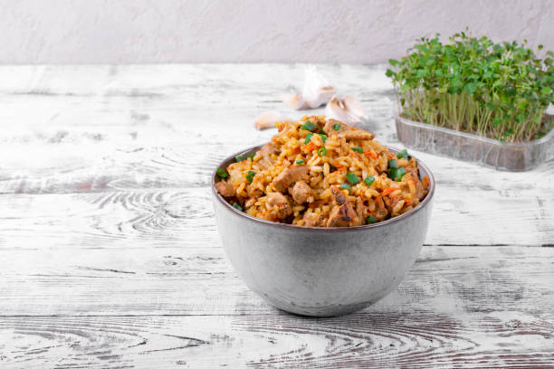 istock Pilaf with meat in a ceramic bowl on the white wooden table 1216998818