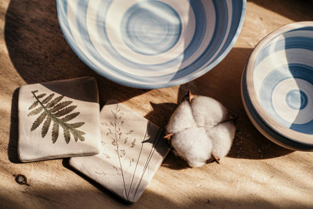 istock Pottery and brushes in ceramic workshop, white blue colours, cotton flowers on wooden table 1217001933