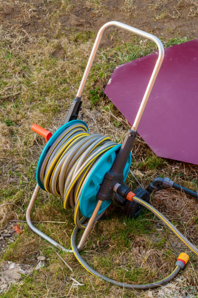 istock Red waterhole caisson hatch and reel with garden watering hose 1217003554