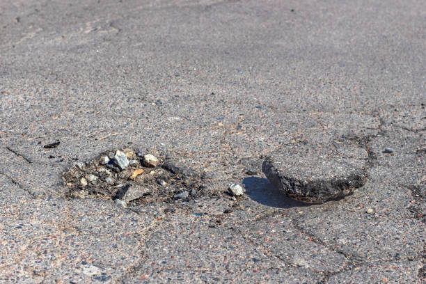 istock A pit with stones on damaged asphalt highway. 1217006717