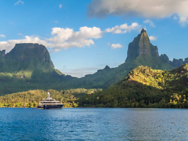 sailing yacht anchored in Opunohu bay, Moorea sailing yacht anchoring in Opunohu Bay in front of famous Mount Mouaroa , Moorea,Society Islands, French Polynesia bora bora mountain stock pictures, royalty-free photos & images