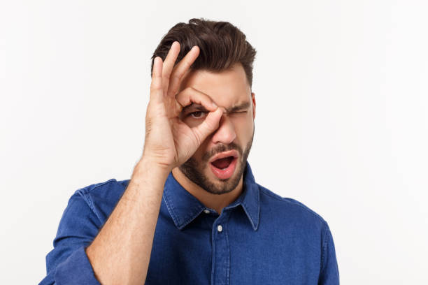 istock Young handsome man with beard doing ok gesture shocked with surprised face, eye looking through fingers. Unbelieving expression. 1217008846