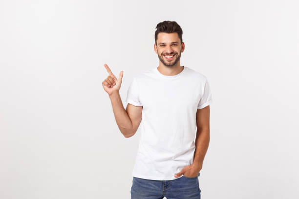 istock Man pointing showing copy space isolated on white background. Casual handsome Caucasian young man. 1217008909