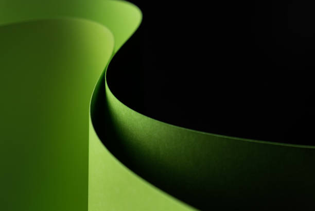 istock Green, waved paper craft on a black background - closeup. 1217008957