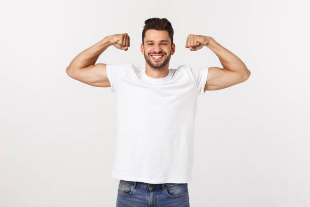 istock Handsome fit young funny bearded man pointing to his bicep and smiling on white background 1217009023