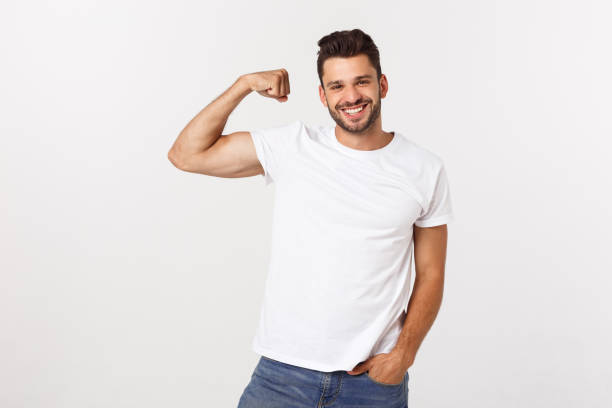 istock Handsome fit young funny bearded man pointing to his bicep and smiling on white background 1217009040
