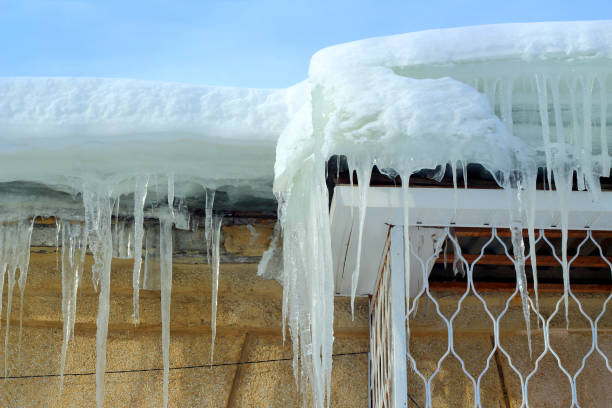istock Icicles on the roof against the blue sky 1217009169