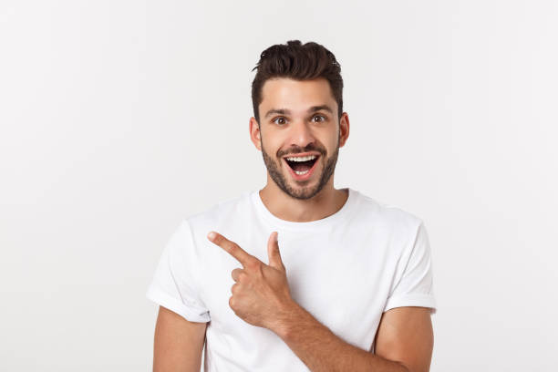 istock Man pointing showing copy space isolated on white background. Casual handsome Caucasian young man. 1217009190