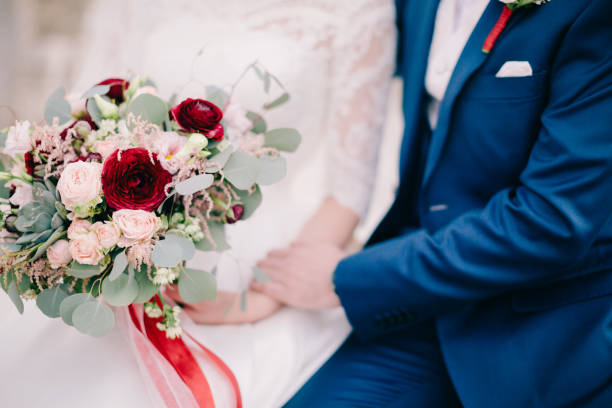 istock bride and groom holding wedding bouquet 1217009221