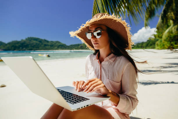 ビーチで女性フリーランサー - on beach laptop working ストックフォトと画像