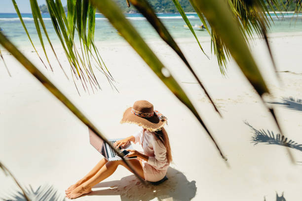 istock Woman working on laptop in tropics 1217010626